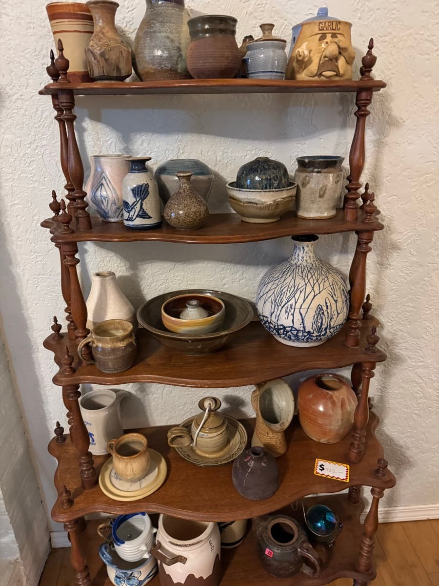 Handmade pottery and stoneware on a wooden display shelf at a Willamette Valley estate sale